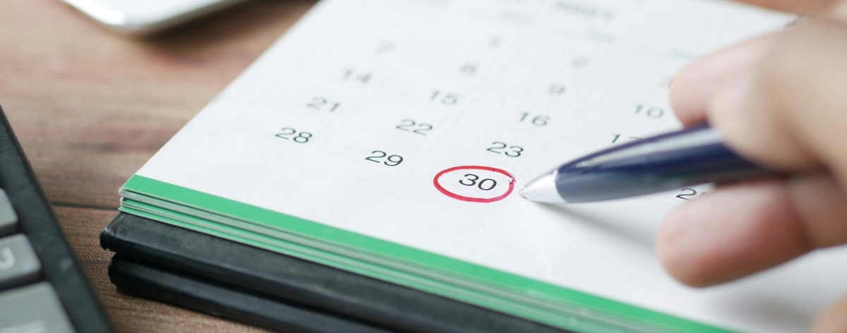 A pen lingers over a circled date on the calendar.