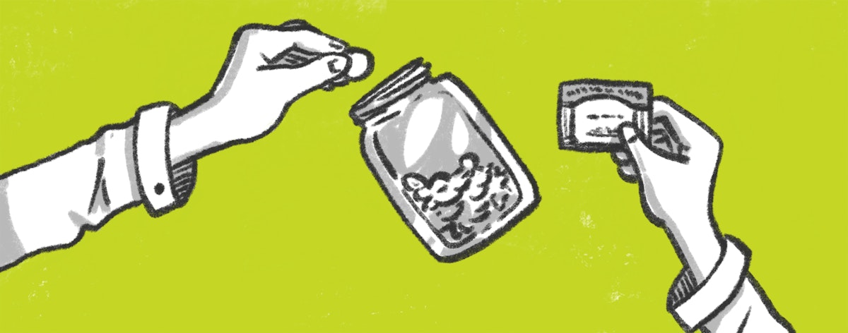 A hand drops coins into a jar.